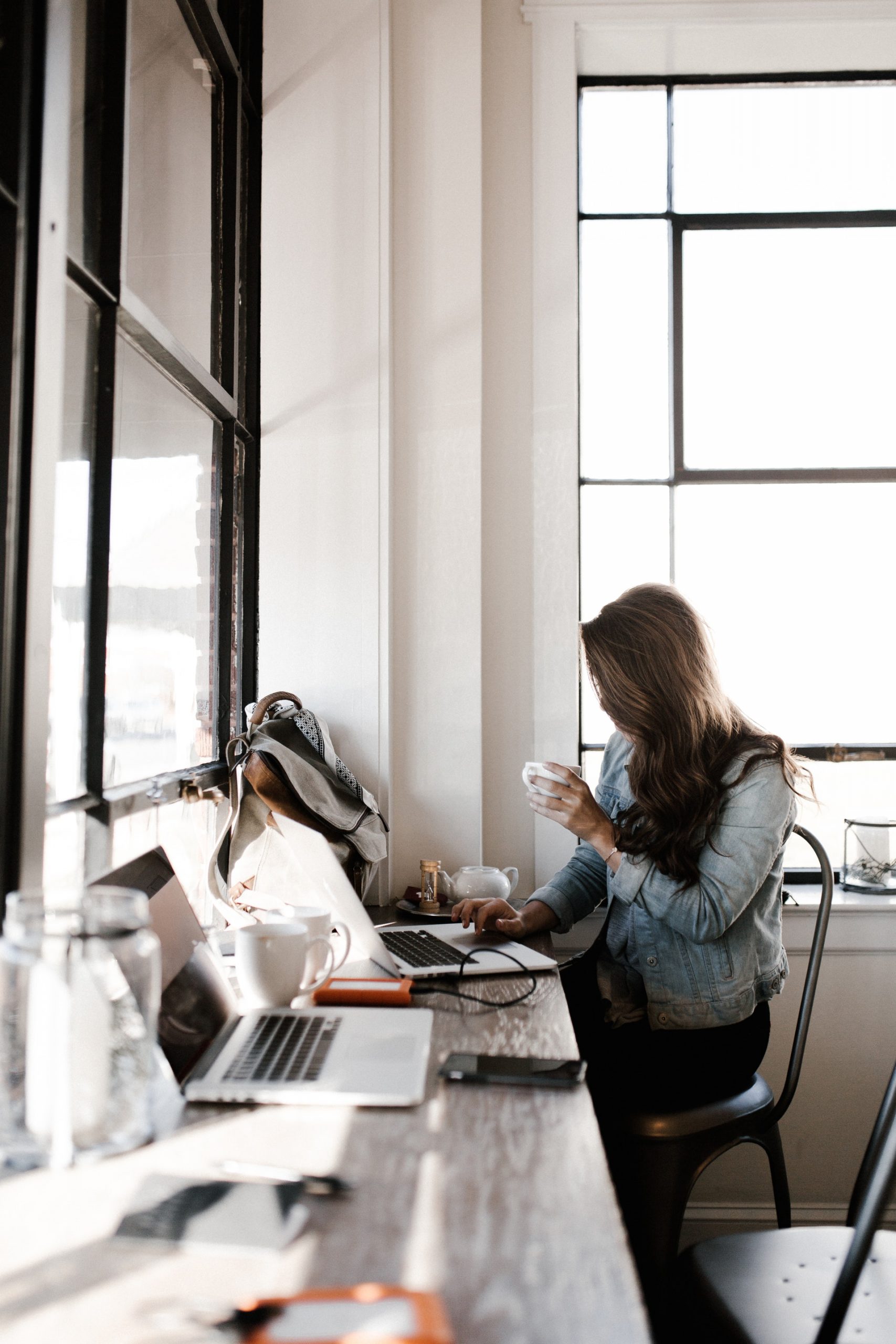 woman in gray jacket sitting beside desk 2682452 scaled